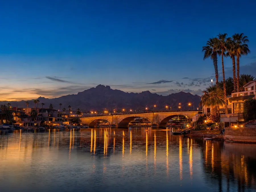 Lake Havasu at dusk with the London Bridge and waterfront homes reflected in calm water