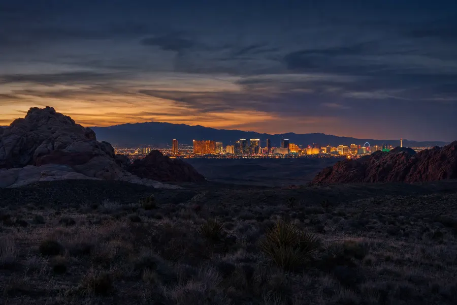 Las Vegas skyline at dusk viewed across desert foothills